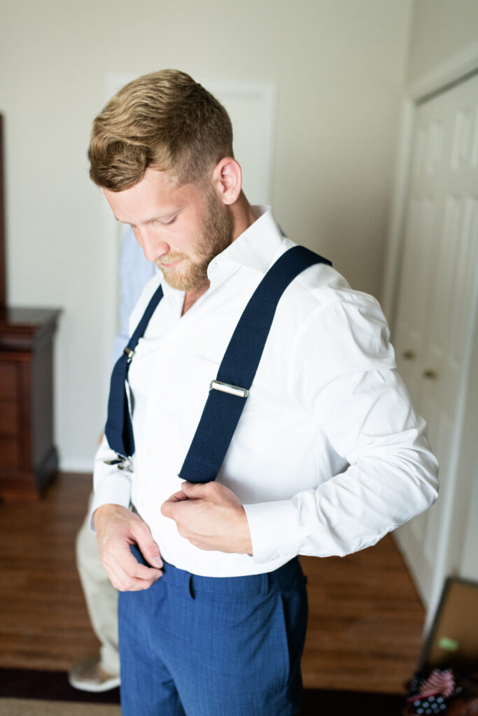 groom getting ready suspenders
