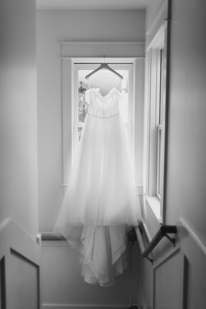 wedding gown hanging in window